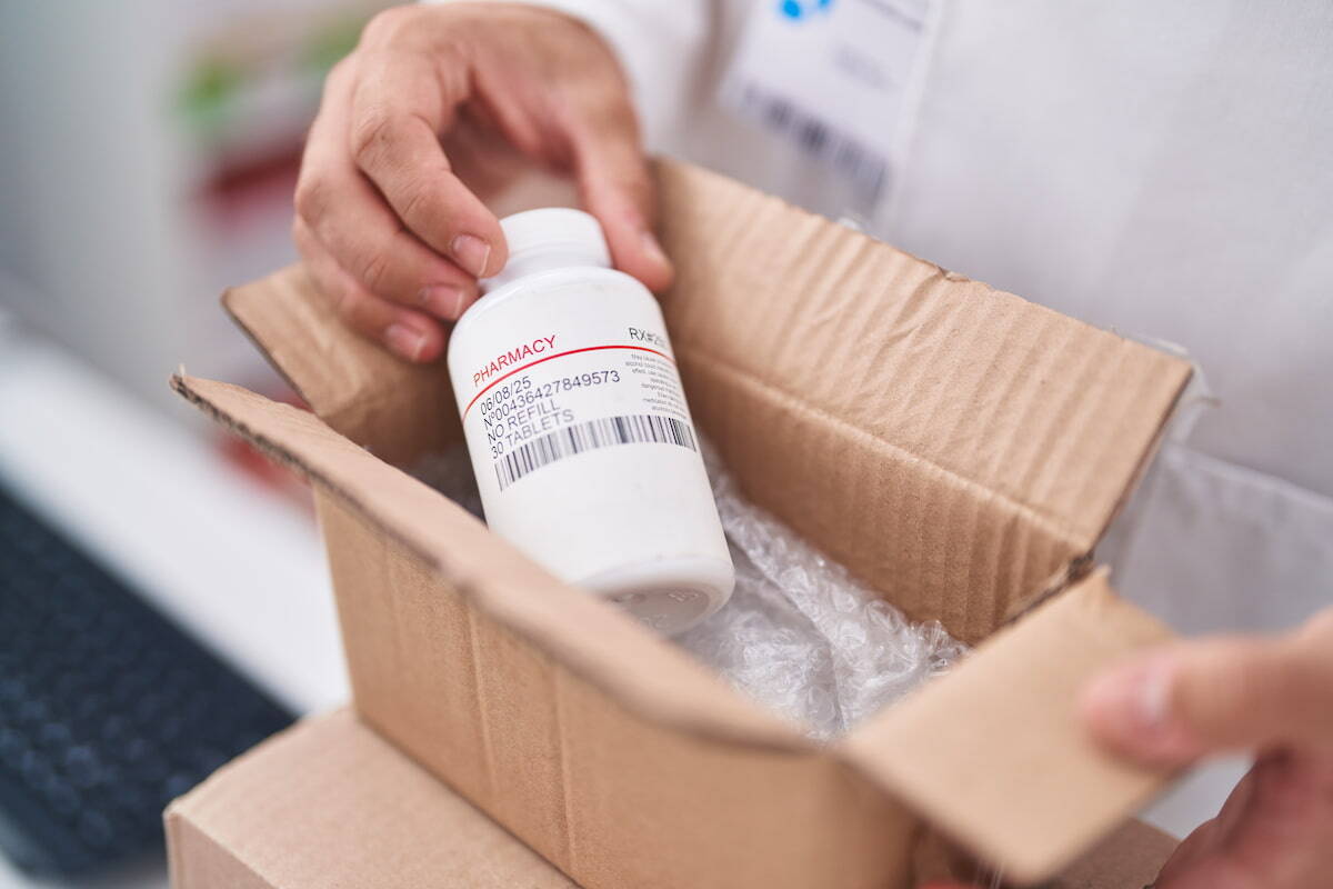 Pair of hands opening a package with medicine inside