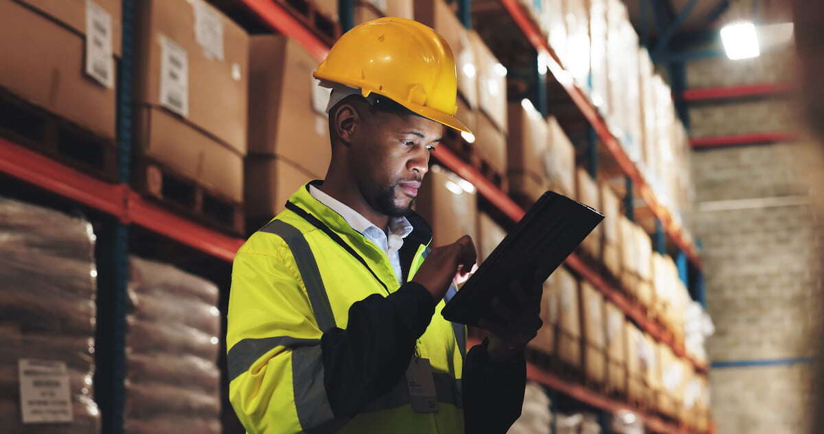Warehouse employee using technology to assist in inventory management and order processing